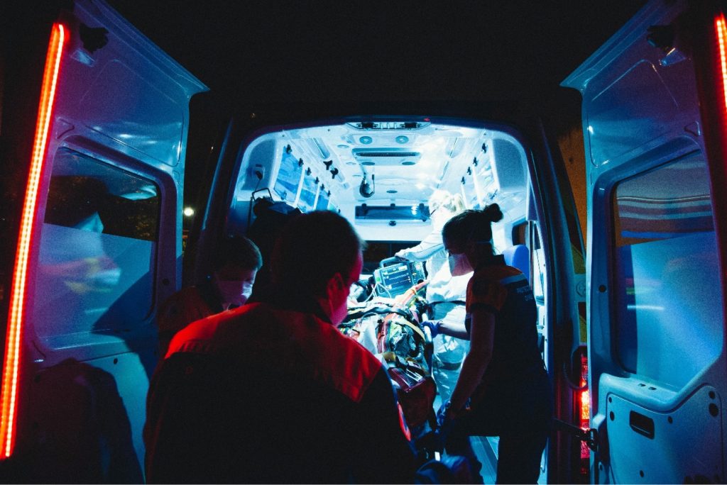 paramedics attend to a patient inside a van